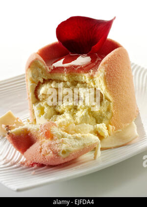 White chocolate cake with a sponge case and strawberry filling, covered with pink white chocolate powder Stock Photo