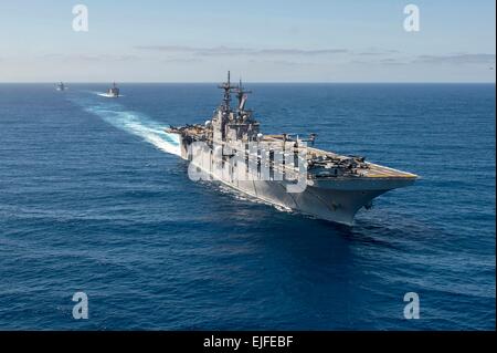 US Navy Wasp-class amphibious assault ship USS Essex followed by the Whidbey Island-class amphibious dock landing ship USS Rushmore and the San Antonio-class amphibious transport dock ship USS Anchorage during a simulated strait transit March 23, 2015 in the Pacific Ocean. Stock Photo
