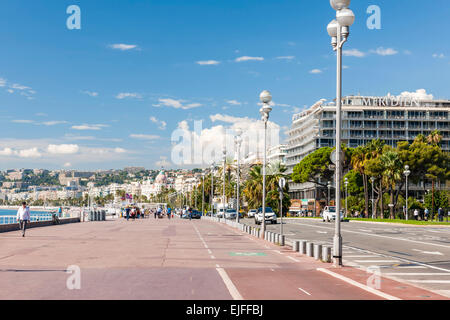 NICE, FRANCE - OCTOBER 2, 2014: English promenade (Promenade des Anglais) runs along city's waterfront near comfortable beach Stock Photo