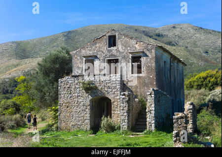 Tourists visiting Skordilis Mansion house ruin in oldest village of Corfu - ancient Old Perithia - Palea Perithea, Greece Stock Photo