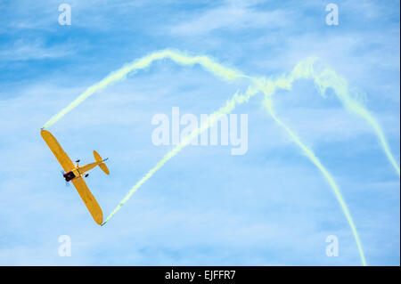 Aerobatic plane with colored smoke trails. Stock Photo