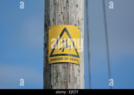 Danger of Death warning sign on wooden pole carrying electricity supply Stock Photo