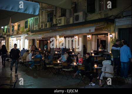 Nighttime cafe society street scene, local people and tourists at pavement cafe bar restaurant in Kerkyra, Corfu, Greece Stock Photo