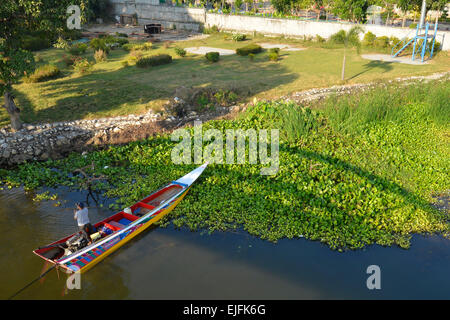 A boat sits under the Death Railway Bridge over the River Kwai, Kanchanaburi, Thailand Stock Photo