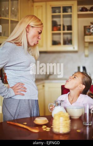 Mother and daughter making face at each other Stock Photo