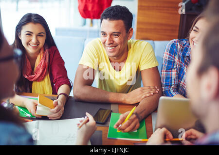 Smiling students having conversation with their friends Stock Photo