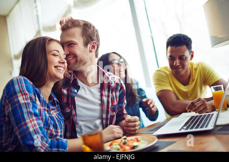 Group of students having dinner and working with computer Stock Photo