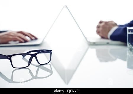 Two businessmen working on table and having different tasks Stock Photo