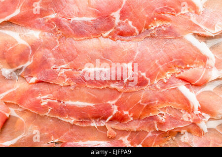 Spanish jamon, dry-cured ham thin slicing for background. Top view Stock Photo