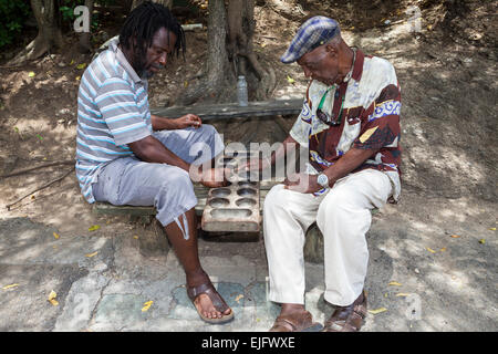 Two local men playing a board game called Warri, Nelson's Dockyard, English Harbour, Antigua, Antigua and Barbuda Stock Photo