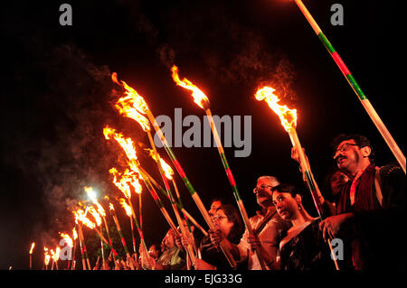 Dhaka, Bangladesh. 25th Mar, 2015. People are lighting up torches, this is known as the black night day. It's the day where the Pakistani army committed genocide in Dhaka; to commemorate that day a group of people light their torches at Central Shaheed Minar, arranged by Ekattorer Ghatak-Dalal Nirmul Committee. They are demanding the observance of March 25 as the `International Genocide Day'. © Mohammad Asad/Pacific Press/Alamy Live News Stock Photo