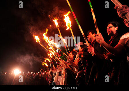 Dhaka, Bangladesh. 25th Mar, 2015. People are lighting up torches, this is known as the black night day. It's the day where the Pakistani army committed genocide in Dhaka; to commemorate that day a group of people light their torches at Central Shaheed Minar, arranged by Ekattorer Ghatak-Dalal Nirmul Committee. They are demanding the observance of March 25 as the `International Genocide Day'. © Mohammad Asad/Pacific Press/Alamy Live News Stock Photo