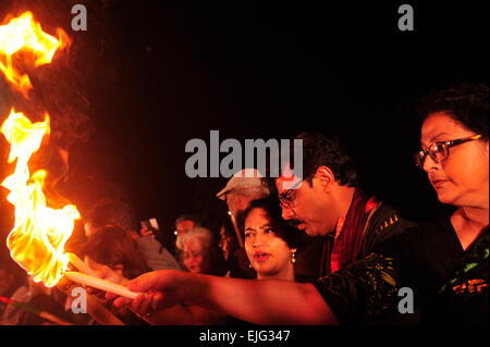 Dhaka, Bangladesh. 25th Mar, 2015. People are lighting up torches, this is known as the black night day. It's the day where the Pakistani army committed genocide in Dhaka; to commemorate that day a group of people light their torches at Central Shaheed Minar, arranged by Ekattorer Ghatak-Dalal Nirmul Committee. They are demanding the observance of March 25 as the `International Genocide Day'. © Mohammad Asad/Pacific Press/Alamy Live News Stock Photo