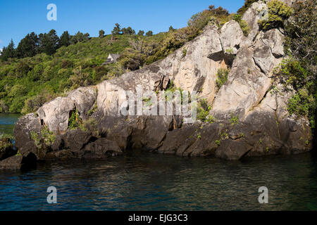 Maori rock carvings seen from a sailboat, Barbary, on Lake Taupo,New Zealand. Stock Photo