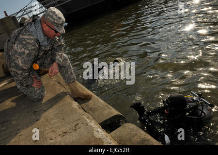 Army engineer divers assigned to the 74th Dive Detachment, Special Troops Battalion, 7th Sustainment Brigade work on patching a portion of the Large Tug-805 one of the brigade's watercraft assets at Fort Eustis' 3rd Port the afternoon of Feb. 2. The divers began the repair project Jan. 30 and are expected to finish the mission Feb. 3.  Sgt. 1st Class Kelly Jo Bridgwater, 7th Sustainment Brigade Public Affairs Stock Photo