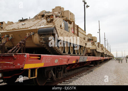 Soldiers from 1st Brigade Combat Team, 1st Cavalry Division move on to the next line of flatbed railcars after loading and chaining down a line of Bradley Fighting Vehicles for transport to Poland, Estonia, Latvia and Lithuania as part of the brigade's participation in Atlantic Resolve, Aug. 19 2014 at Fort Hood, Texas.  Staff Sgt. Keith Anderson, 1BCT PAO, 1st Cav. Div. Stock Photo