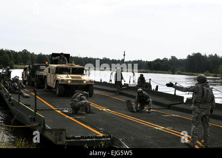 After floating across a large body of water, combat engineers assigned to the 652nd Engineer Company prepare to off-load tactical vehicles using a pontoon-style bridge system while on Fort McCoy, Wis., June 15, 2012.  Spc. Hector Corea Stock Photo