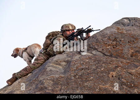 U.S. Army Staff Sgt. Sean Pabey, truck commander, Sgt. James Carlberg dog handler and his dog Staff Sgt. Abby, assigned to 1st Platoon, Apache Company, 3-15th Infantry Brigade, provide overwatch from the mountain tops of Maiden Shar, Afghanistan, Sept. 1, 2013 during operation Apache Shield.  The operation allows U.S soldiers to assist the Afghan Military Police by showing a larger presence on the surrounding mountain tops to deter any enemies of Afghanistan in the area from launching indirect fire onto Forward Operating Base Airborne.  Staff Sgt. Rachel M. Copeland Stock Photo