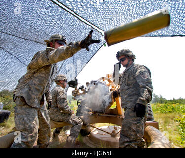 U.S. Army Sgt. Adam Phillips tosses an empty canister from an M119A2 105mm howitzer during platoon evaluations at Fort Bragg, N.C., on June 15, 2011.  Phillips is a paratrooper assigned to the 82nd Airborne Division's 3rd Battalion, 319th Airborne Field Artillery Regiment, 1st Brigade Combat Team.   Sgt. Michael J. MacLeod, U.S. Army. Stock Photo