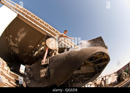 Helicopter repairer Spc. Zachary Provenzano sprays down a Chinook helicopter in preparation for its return from Iraq to the U.S. this month. His unit, D Company, 2nd General Support Aviation Battalion, 1st Aviation Regiment, Enhanced Combat Aviation Brigade, 1st Infantry Division,  is scheduled to redeploy to Fort Riley, Kan., this spring. Provenzano and other Chinook helicopter repairers are charged with breaking down the aircraft so that they can be inspected by customs officials and flown to the states Stock Photo