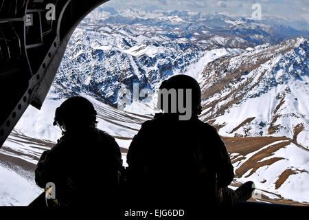 Two crew members keep watch on the rear ramp of a CH-47 Chinook while flying over the mountains in the Khas Uruzgan district of Afghanistan on March 16, 2013.  Sgt. Jessi Ann McCormick Stock Photo