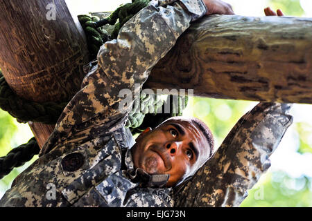 U.S. Army Staff Sgt. Victor Marquez-Rodriguez Sr., Fort Sill, Okla., drill sergeant, climbs across a log to get to a waiting rope that he can use to lower himself down on the confidence course at Fort Eustis, Va., June 27, 2012, as part of the annual Drill Sergeant of the Year competition, hosted by Initial Military Training, U.S. Army Training and Doctrine Command. The yearly competition is designed by the previous yearâ€™s winner and is meant to challenge each drill sergeant, both physically and mentally. Stock Photo