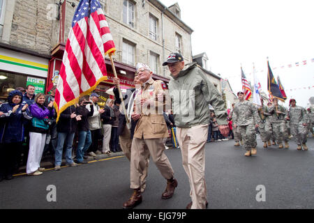 Zane Schlemmer, a veteran U.S. Army paratrooper who jumped into northern France as a sergeant with the 82nd Airborne Division, walks in his jump boots down the main street of Sainte Mere Eglise with other World War II veterans during the 67th anniversary of the Allied invasion of France, June 5, 2011.  French citizens applaud as he and current paratroopers with the 82nd and other Army units parade past.   Sgt. Michael J. MacLeod Stock Photo