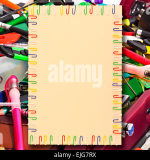 illustration of a sheet of A4 paper in a frame of colored paper clips in the background stationery Stock Photo