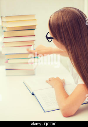 little student girl in eyeglasses with many books Stock Photo