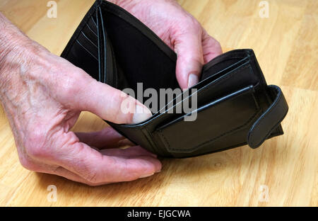 pensioner holding open empty wallet Stock Photo