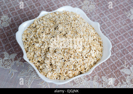 Dry oatmeal in a plate on  table Stock Photo