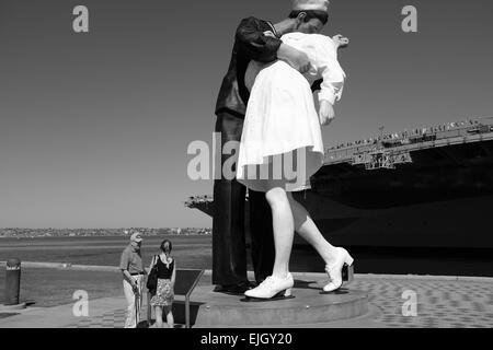 USS Midway on the waterfront in San Diego, and statue of Sailor Kissing Girl at the end of World War II Stock Photo