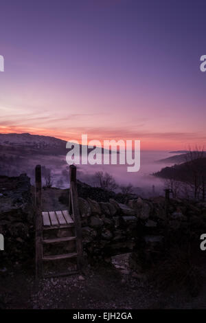 Winter scene: Beautiful pink sunrise scene looking into Ambleside at sunrise from the side of the Fairfield horseshoe, The Lake District, England Stock Photo