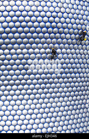 Workmen cleaning the decorative discs on the exterior of the Selfridges building in Birmingham Stock Photo