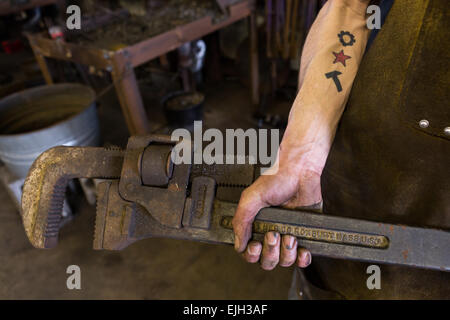 Blacksmiths hands on a giant wrench in a metal working shop in Charleston, SC Stock Photo
