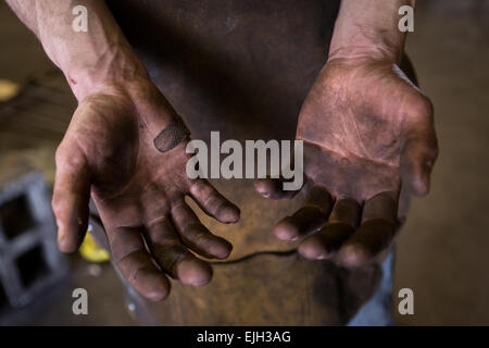 Blacksmiths hands covered in dirt in a metal working shop in Charleston, SC Stock Photo