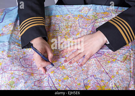 Airline officer wearing four gold braid rings on the sleeve planning a route Stock Photo
