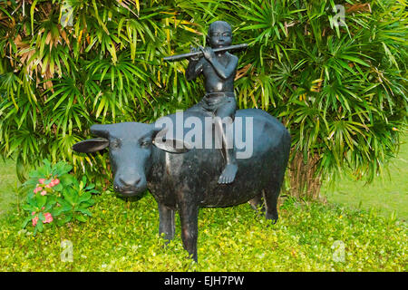 Statue of boy playing flute on water buffalo, Magelang,Central Java, Indonesia Stock Photo