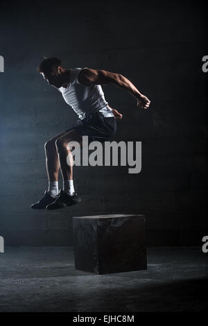 Athlete gave exercise. Jumping on the box. Phase touchdown. Stock Photo