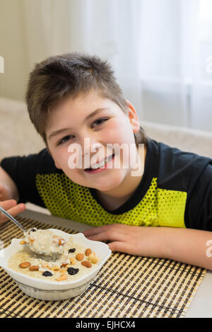 Teenager boy has oatmeal for breakfast Stock Photo