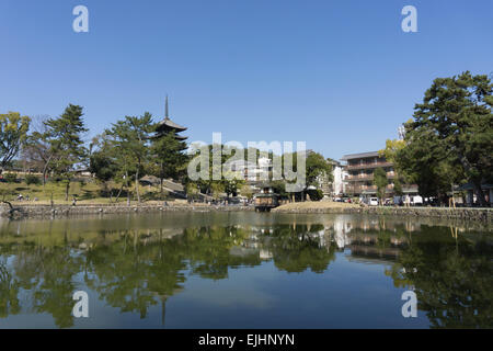 Japanese pagoda tower of Kofukuji temple in Nara, Japan reflected in the waters of Sarusawa Pond on a sunny day Stock Photo