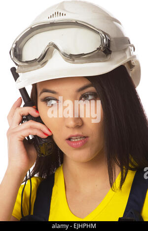 Serious female construction worker talking with a walkie talkie Stock Photo