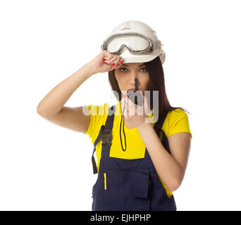 Serious female construction worker talking with a walkie talkie Stock Photo