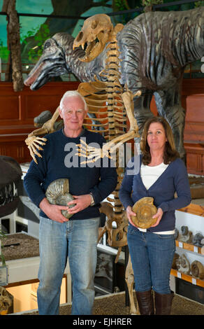 Dinosaurland Fossil Museum in Lyme Regis,Dorset,UK with owners Steve & Jenny Davies with a fossilised cave bear, mamouth tusks and ammonites. Stock Photo