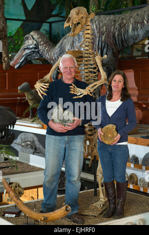 Dinosaurland Fossil Museum in Lyme Regis,Dorset,UK with owners Steve & Jenny Davies with a fossilised cave bear, mamouth tusks and ammonites. Stock Photo