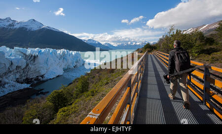 Photographer walking on the footbridge. Perito Moreno glacier. Los Glaciares National Park. Patagonia. Argentina Stock Photo