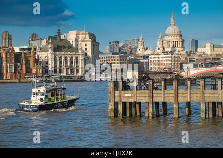 London skyline buildings with passing Police boat on River Thames. Stock Photo