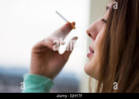 Woman enjoying her cigarette in the morning on the terrace Stock Photo