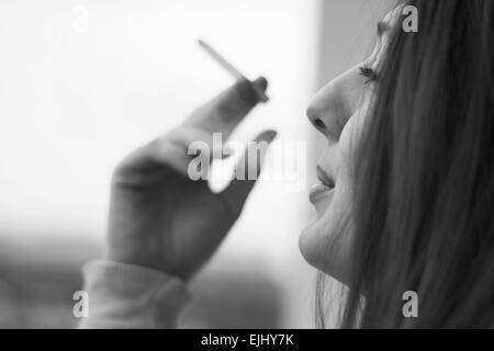 Woman enjoying her cigarette in the morning in black and white Stock Photo