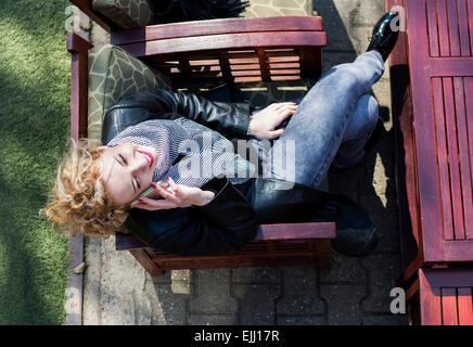 Pretty and attractive young woman with blond curly hair talking on the phone,shot from above. Stock Photo